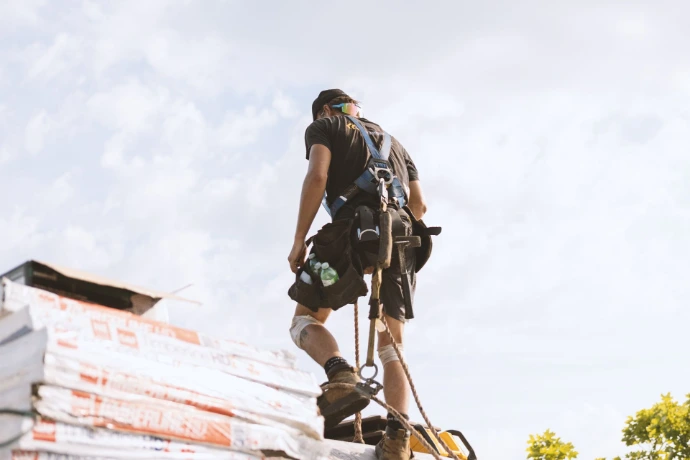 Couvreur professionnel en pleine installation de toiture résidentielle.
