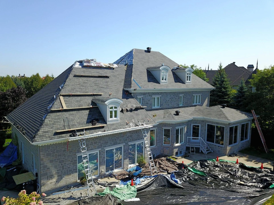 Chantier de rénovation de toiture sur une maison à étages.