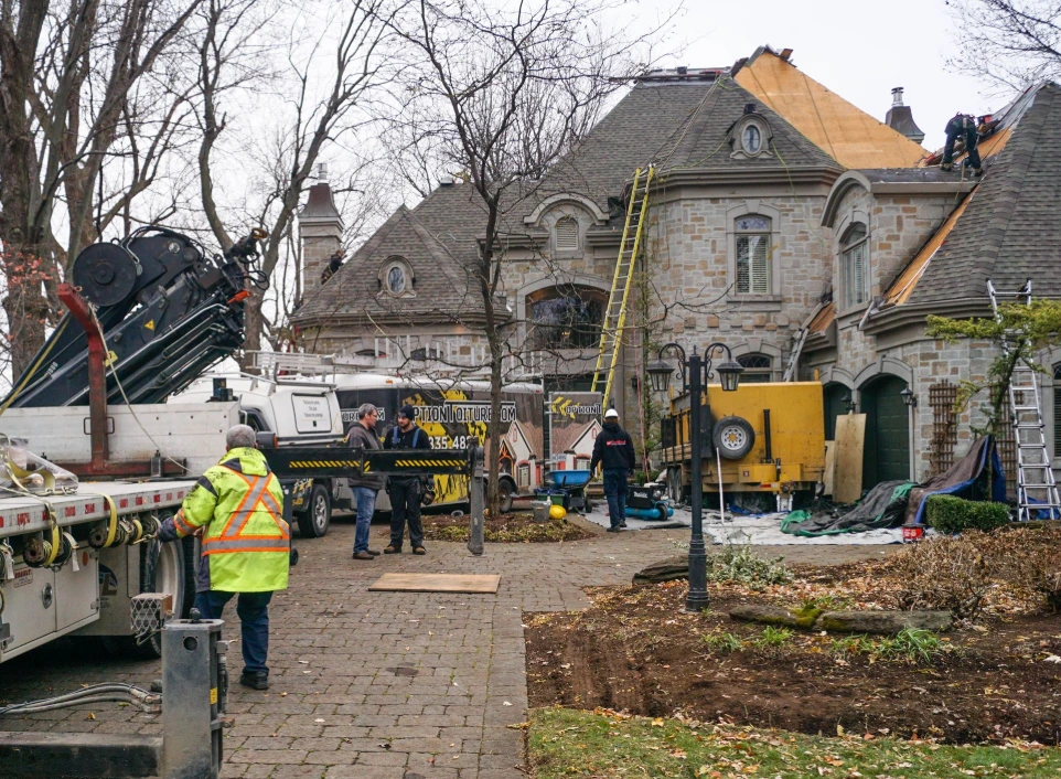 Équipe de couvreurs et équipement sur un projet de réfection de toit.